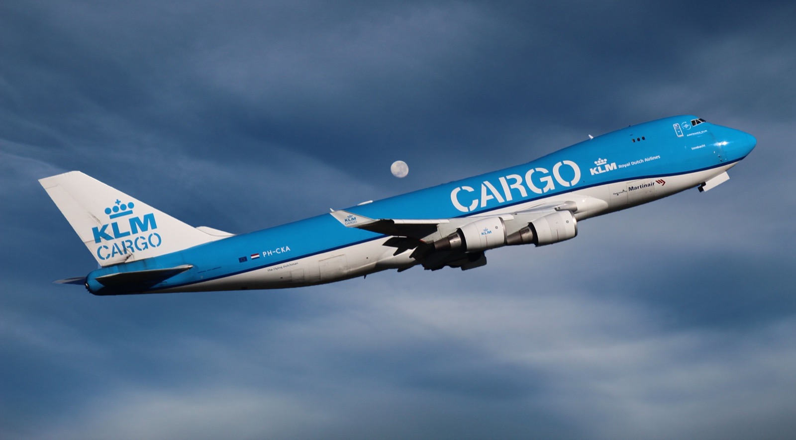Avión carguero de fuselaje ancho despegando al atardecer